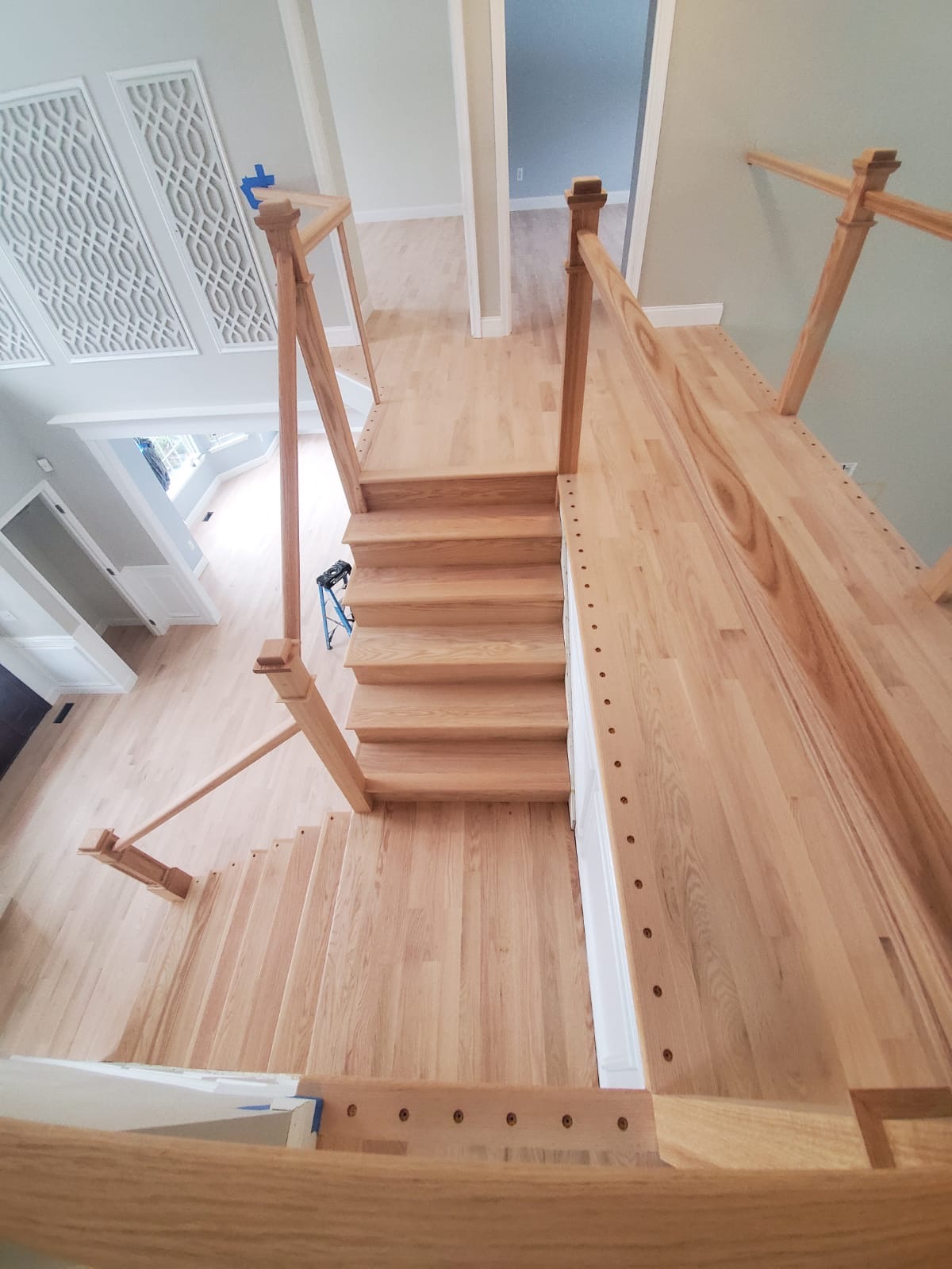 Stair treads and landing with light wood exposed during sanding and preparation