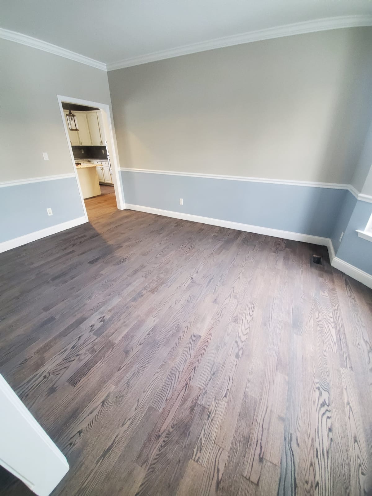 Dark stained hardwood floor with visible wood grain in a dining room