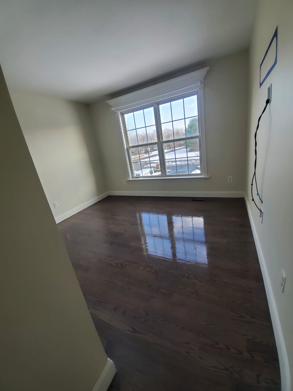 The same room with dark hardwood after a coat of finish was applied